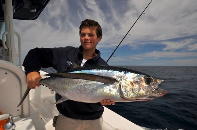 13 year old Will proudly hoists his first longfin tuna that he wrenched in all by himself. Thanks to the Saltwater Edge for the photo.