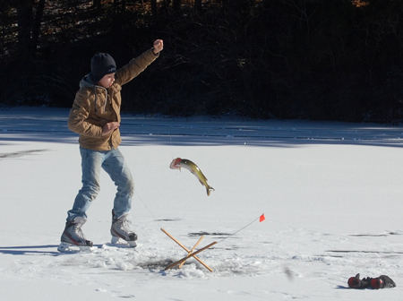 Spencer Campbell of Pembroke, MA Takes a fish through the ice.