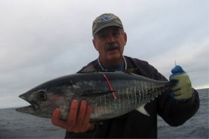 Captain Al Anderson holds a freshly tagged one-year-old bluefin tuna. The tag will allow scientists to track the fish's growth and movement if the fish is recaptured. (Photo courtesy of Al Anderson)