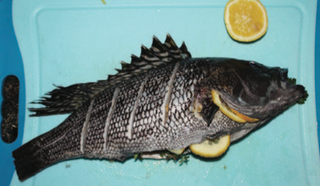 Stuff the fish with lemon wedges and fresh herbs, then coat it with olive oil and salt.