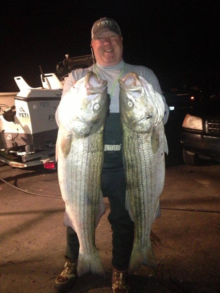BJ Silvia of Flippin' Out Charters with two nice stripers taken from the surf last weekend.