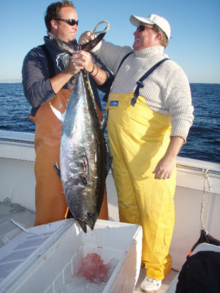 Chris Glass and Paul Murray of RockOn products heft an 80-pound tuna that took one of their squid bars