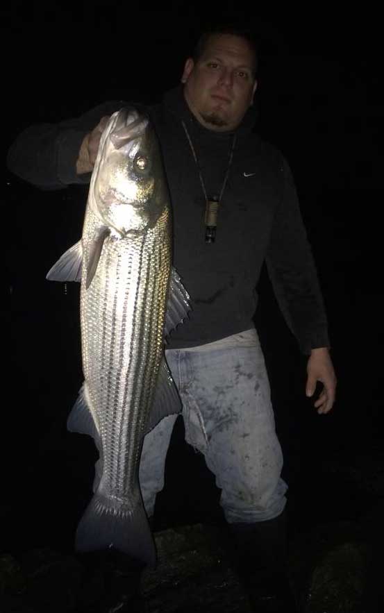 Jason Jadach with an early-season keeper striped bass.