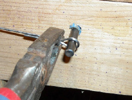 The eye of the plug is bent around a large nail or peg.