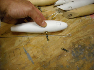 The through-wire is threaded through a swivel that will hold the belly hook.