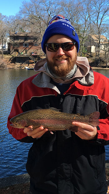 Josh Farr with a rainbow trout he hooked in Sluice Pond in Lynn