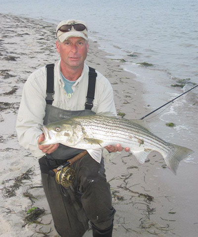 Fly-fisherman Eric Romanowski holds a keeper-size spring striper.