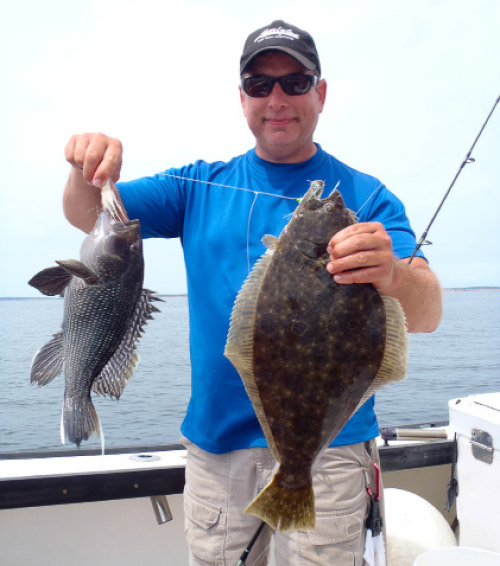 Captain Tom with a fluke on the teaser and a sea bass on the bucktail.