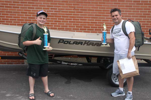 Keegan Walczak with his dad, Chris in front of Keegan's new boat!