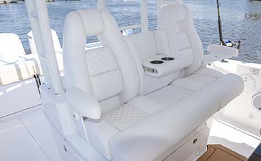 Helm seat with folding bolster, arm rests, and drink holder