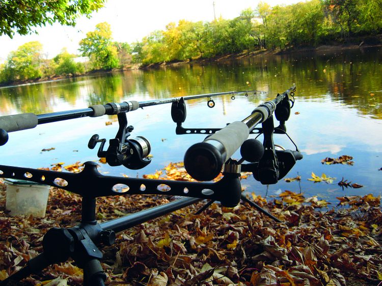 A couple of outfits sit on a rod pod waiting for a hit along the Merrimack River. Note the bait-feeder reels, probably the most important piece of equipment for carp fishing.