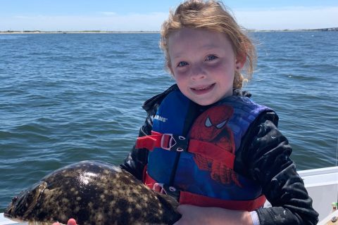 7-year-old Julia Moore holding a fluke that was caught in Sandy Hook Bay, New Jersey.