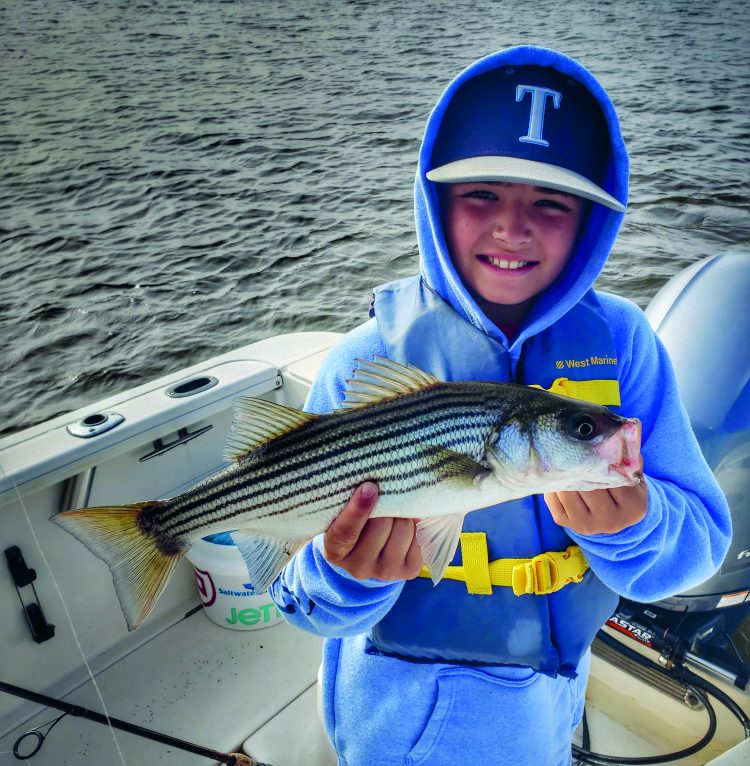 Boy holding striped bass