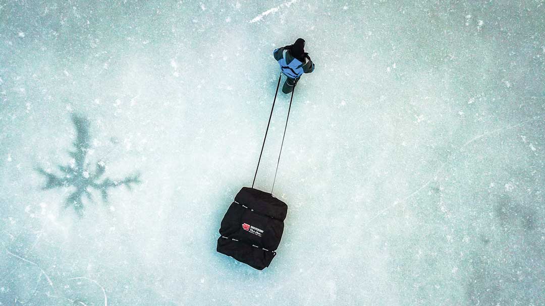 ice fisherman with pull harness and sled
