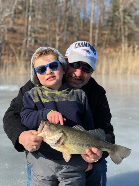 father and son with largemouth on ice