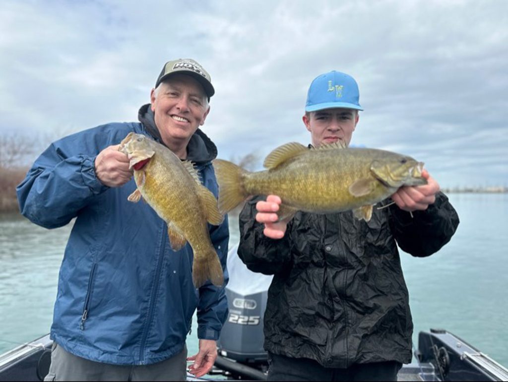 Steven Mosher and his son Ethan with pair of smallmouth bass.