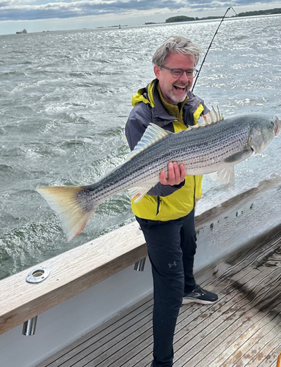 Christopher DeLaure with striped bass
