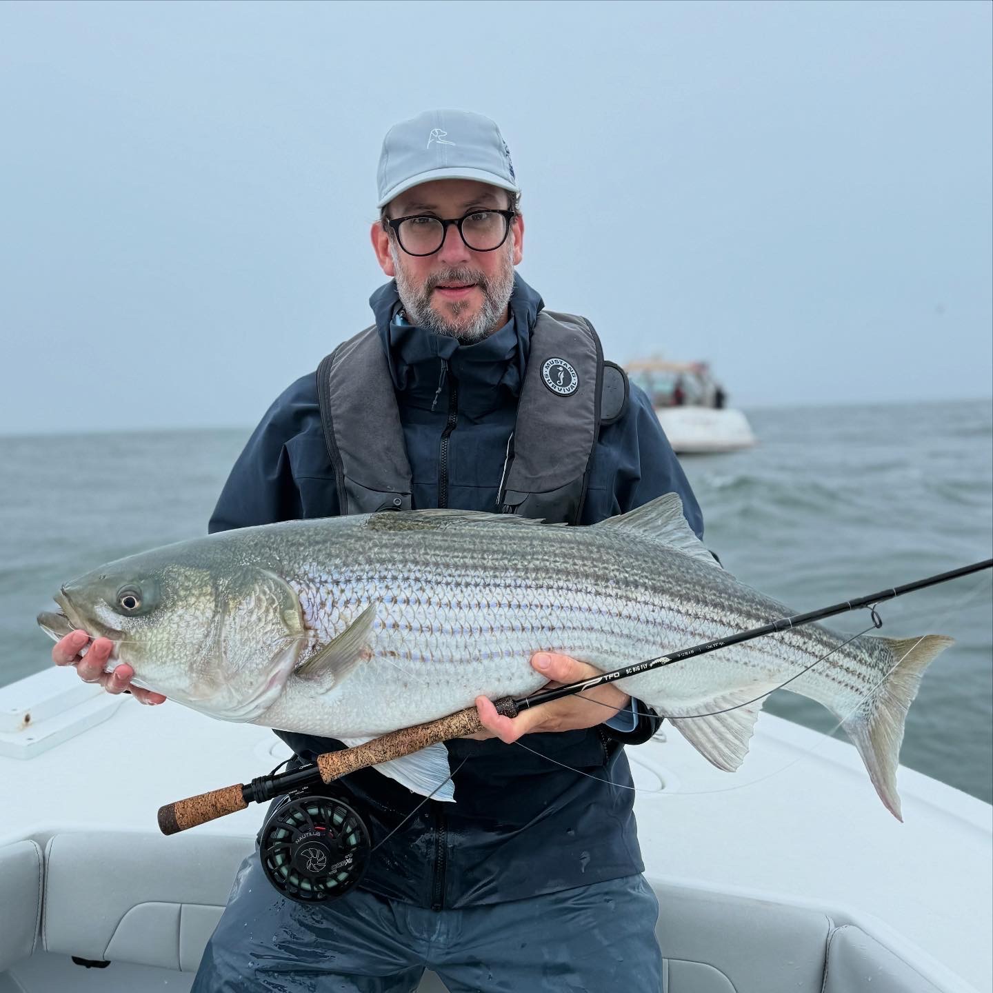 Fly angler fighting a striped bass on Long Island Sound with North Island Fly